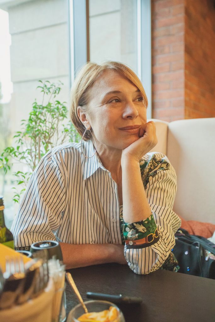 Mature woman with short ginger hair resting in cafe